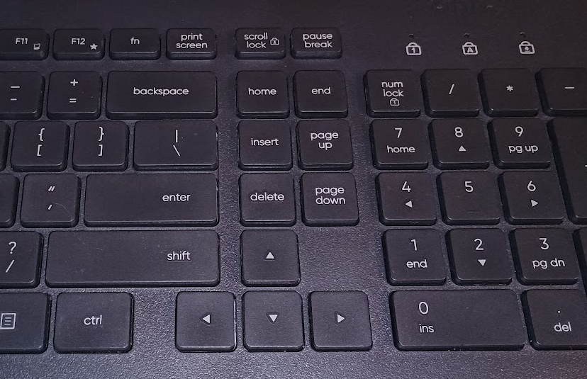 Photo of the right-hand side of a keyboard, from about the Enter key to the end of the numpad. Of note, the Home cluster of keys is two columns instead of three, and Print Screen is where F12 should be.